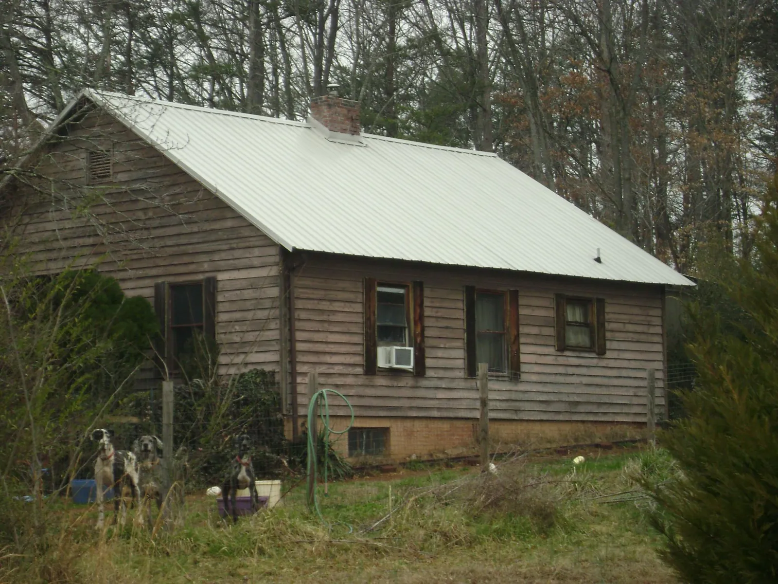 White metal roof on an old wood sided farmhouse, from a Metal Roof Installation job in Fort Belvoir